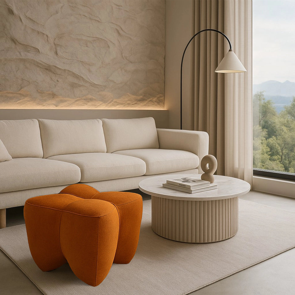 Modern living room with beige sofa, orange poufs, and round coffee table.
